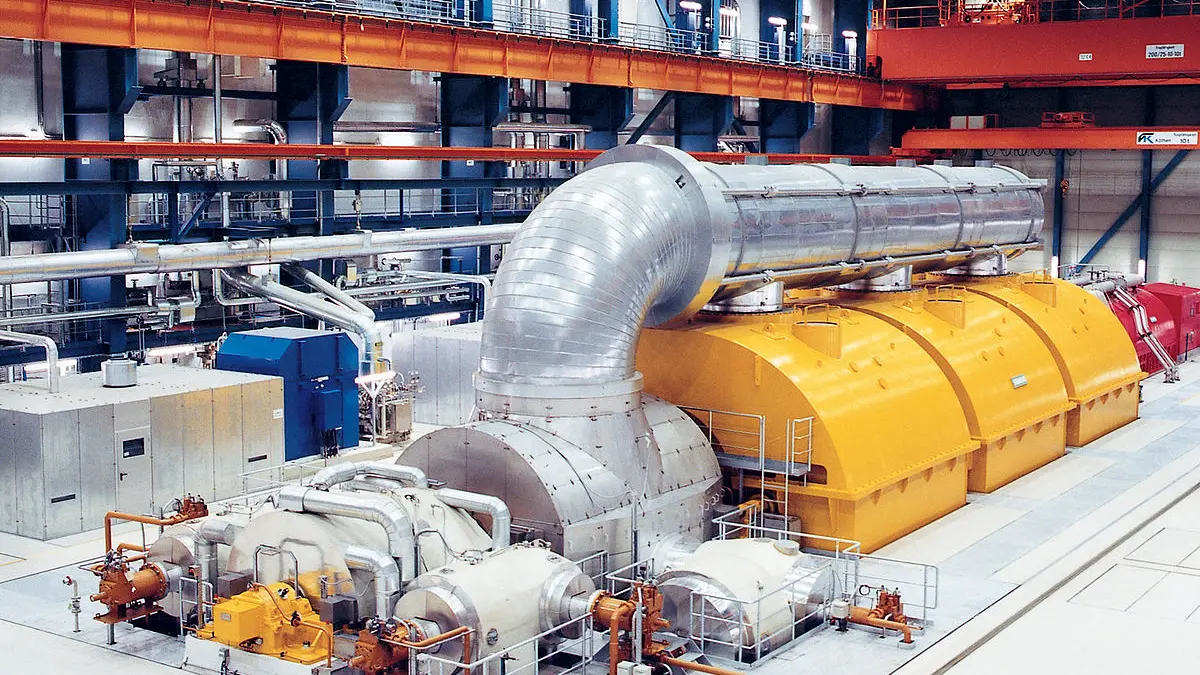 Turbina de vapor Siemens en una planta de generación de energía con carcasas amarillas y tuberías metálicas